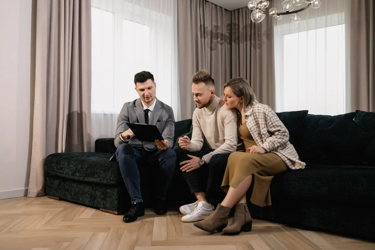 Agent going over the asking price with homeowners on their sofa