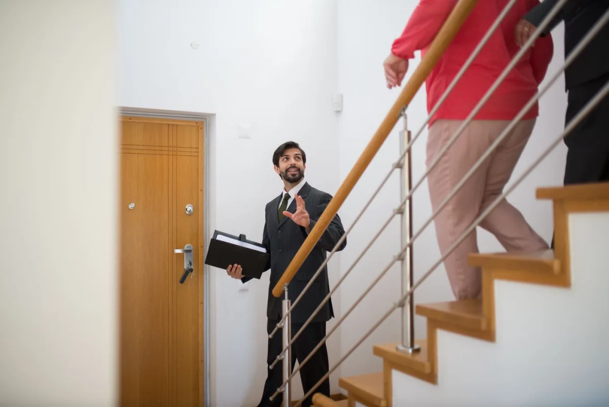 Agent leading buyers up the stairs during a home tour