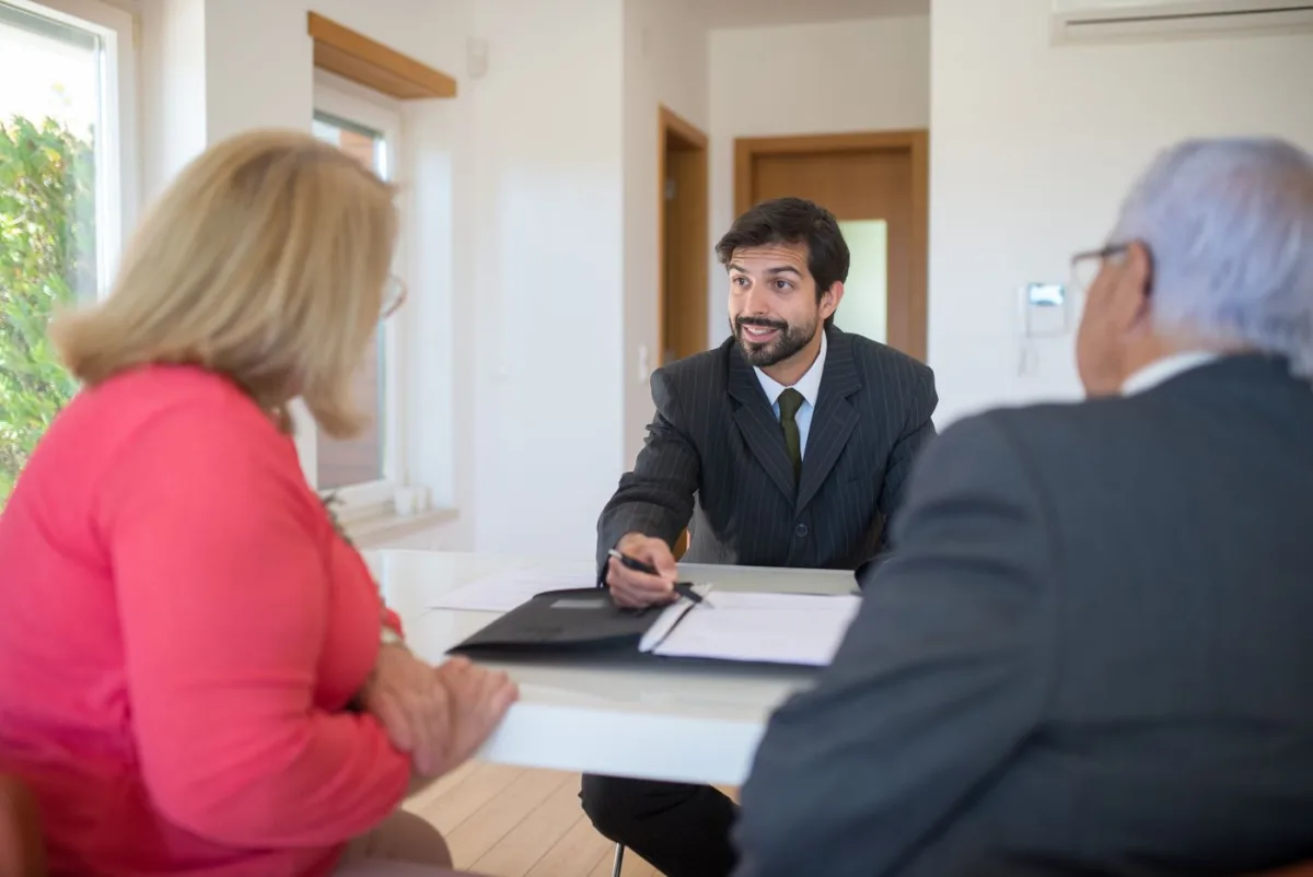 Consultant talking a couple through property figures across a table