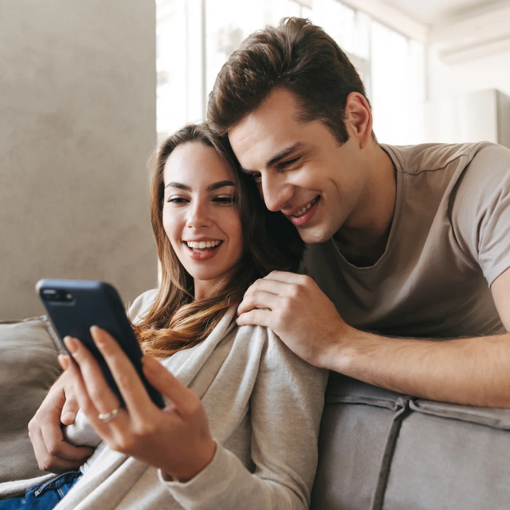 Couple browsing homes for sale on a phone